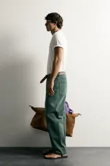 Jeans relaxed fit de algodón color verde oscuro, de tiro medio y pernera recta con raya de planchado. Cuenta con diseño de cinco bolsillos y cierre frontal con cremallera y botón.