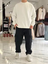Buzo oversize de corte amplio, color blanco, con cuello redondo y puños y dobladillo en rib elástico.