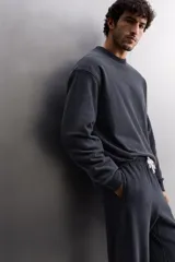 Sudadera negra de entrenamiento relaxed fit confeccionada en tejido de algodón con interior rizo, cuello redondo, manga larga y acabados en rib.