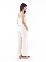 Top corto color blanco roto, de tejido con textura, con tirantes anchos y escote cuadrado.