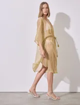 Kaftan dorado con brillo, de manga corta amplia y escote en V. Posee jareta interna ajustable en la cintura y tajo lateral.