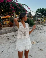 Pollera corta de color blanco con diseño de volantes escalonados, confeccionada con short interior incorporado y cintura elástica.
