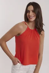 Blusa color coral con cuello halter y tirantes finos.