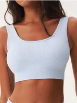 Top deportivo de tejido acanalado sin costuras, con escote redondo y diseño de espalda estilo nadadora. Ofrece un ajuste ceñido y soporte medio.