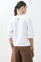 Remera blanca de algodón con mangas cortas abullonadas.