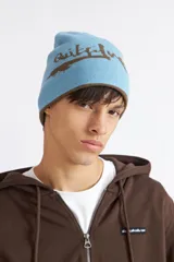 Gorro reversible de invierno Quiksilver, color marrón con diseño estampado y detalles en celeste.