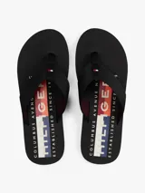 Ojotas negras con suela de EVA y tiras de tejido trenzado en color negro. Presentan un logo bordado en la tira del dedo.