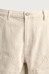Bermuda relaxed fit color marrón con efecto lavado, cinco bolsillos, bolsillos frontales de carpintero y cierre frontal con cremallera y botón.