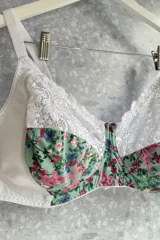 Soutien reductor con aro, confeccionado en lycra estampada con flores y puntilla negra. Breteles regulables.