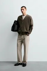 Cárdigan de hombre color negro, de corte regular fit, tejido en estructura compacta, con cuello pico, manga larga y cierre frontal de botonadura.