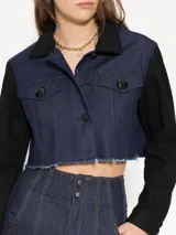 Campera corta de denim azul con mangas largas negras y cuello clásico negro.