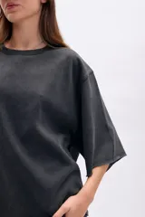 Remera oversize de manga corta con efecto lavado en color negro, cuello redondo y terminaciones deshilachadas.