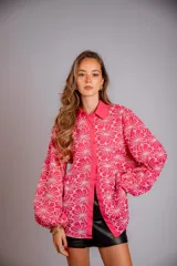 Camisa de manga larga con diseño abullonado, confeccionada en tela bordada con motivos florales. Presenta cierre frontal con botones y puños elásticos.