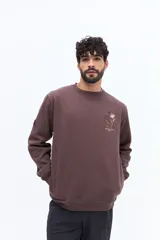 Buzo de algodón azul marino, corte regular, con cuello redondo. Presenta un bordado de flores y texto en el pecho.