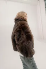 Campera bomber de piel sintética en color marrón chocolate, con diseño de cuello alto, cierre frontal y puños elásticos en color negro.