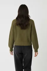 Sweater de algodón color verde militar, de punto grueso, con cuello polera y manga larga.