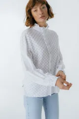 Camisa blanca con textura, cuello alto con volados y cierre frontal con botones.