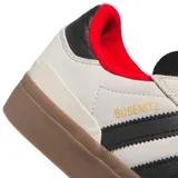 Championes de skate Adidas modelo Busenitz Vulc II, con diseño en color crema, detalles en negro y suela de goma color marrón. Presenta el logo de la marca en los laterales y cuello acolchado en color rojo.