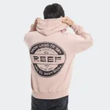 Campera con cierre frontal y capucha, color beige, con logo circular de la marca Reef estampado en el pecho y bolsillos tipo canguro.