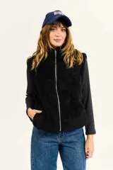 Chaleco Billabong modelo Mystic Vest color negro, confeccionado en tejido efecto corderito, con cuello alto, cierre frontal y bolsillos laterales.