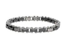 Pulsera de eslabones tipo cadena fabricada en acero inoxidable y piezas de cerámica negra, con detalle de eslabón central incrustado con pequeñas circonias.