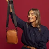 Bandolera de cuero sintético color negro, con doble cierre superior y correa de galón ajustable. Incluye un bolsillo interior de fácil acceso.