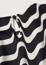 Vestido corto de manga larga con cuello redondo, confeccionado en tela satinada con estampado geométrico de ondas en blanco y negro.
