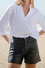 Short de cuero plateado con acabado metalizado y efecto arrugado, corte estilo jean de tiro medio y largo por encima de la rodilla.