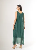 Vestido largo de seda italiana en color verde inglés, con tirantes anchos, escote redondo y diseño holgado con frunces. Cuenta con forro interior de viscosa elastizada.