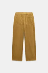 Pantalón de tiro medio confeccionado en tejido de pana, con diseño de pierna ancha, bolsillos delanteros y traseros, y cierre frontal con cremallera y botón.