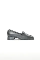 Mocasín de cuero negro liso combinado con cuero texturado en la capellada, con punta redondeada y taco medio ancho.