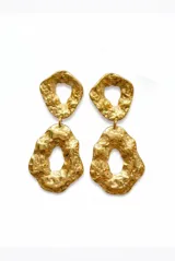 Par de aros colgantes dorados de acero con diseño orgánico y textura irregular, compuestos por dos piezas con forma de anillos abiertos.