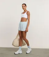 Short deportivo estilo runner de color celeste, con cintura elástica y diseño holgado con aberturas laterales.
