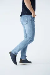 Pantalón de jean corte regular, color azul oscuro, con diseño de cinco bolsillos, pasacintos y detalles de roturas localizadas en la parte frontal.