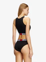 Top deportivo de algodón elástico color blanco, con cuello redondo y banda elástica ancha en la base con el logo de la marca estampado en contraste.