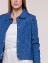 Chaqueta azul de algodón con diseño acolchado y bordado de flores, cuello redondo y cierre frontal con botones a presión metálicos. Incluye bolsillos delanteros y forro interno a tono.