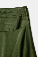 Falda corta de satén color verde oliva, con cintura fruncida y dos niveles de volantes con terminación ondulada.
