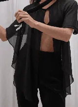 Capa corta color fucsia de gasa, estilo torerita, con mangas amplias y abertura frontal.