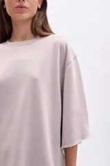 Remera oversize de manga corta con efecto lavado en color beige, cuello redondo y terminaciones deshilachadas.