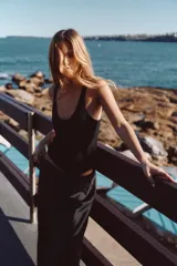 Falda midi negra de tejido satinado, corte recto y tiro alto con cintura elástica.