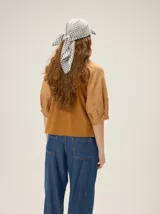 Gorro pañuelo color beige, con visera incorporada y diseño liviano con detalles deshilachados en el borde de la visera.