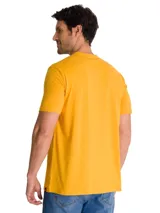 Remera Caterpillar de color amarillo, con cuello redondo y mangas cortas. Presenta un estampado gráfico circular en el pecho con diseño vintage inspirado en tractores.