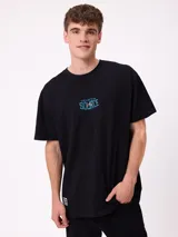 Remera de corte oversize color crema con estampado gráfico en la espalda que muestra un oso, un paisaje natural y el texto 'Stay close to the source'.