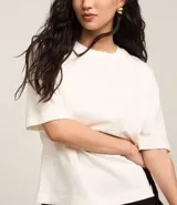 Blusa básica de mujer color negro, confeccionada en malla encorpada de algodón, con cuello redondo y mangas cortas de corte oversized con sisas desplazadas.