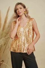 Musculosa de lentejuelas doradas con doble escote en V, tanto en el frente como en la espalda. Presenta breteles anchos y un corte levemente acampanado.