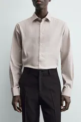 Camisa de hombre color beige claro, de corte slim fit, con cuello italiano, manga larga y cierre frontal de botonadura.