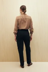 Pantalón negro de algodón, de tiro alto y corte recto, con bolsillos delanteros amplios con botones.