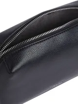 Cartera bandolera Calvin Klein modelo Camera, color negro con textura granulada y logo de la marca en el frente. Tiene correa de cadena plateada y cierre superior con cremallera.