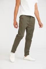 Pantalón cargo color beige de corte slim, con cierre y botón frontal, y bolsillos laterales tipo cargo con cierre.