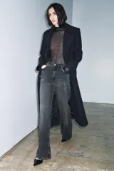 Jeans de tiro alto con corte wide leg y largo completo. Presenta diseño de cinco bolsillos, trabillas en la cintura y cierre frontal con cremallera y botón, con un acabado de efecto lavado.